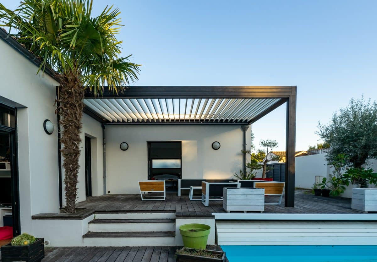 Pergola bioclimatique en aluminium aux lames orientables installée sur une terrasse