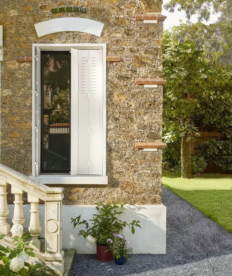 Persienne fer blanche KparK sur une maison en pierre meulière