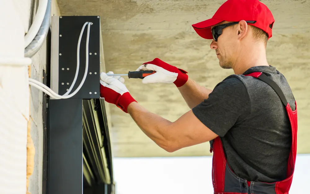 Technicien réparant la motorisation électrique d'un volet roulant